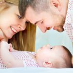 Rodzice patrzący na swoje roczne dziecko - Planowanie rodziny