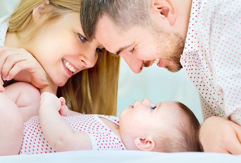 Rodzice patrzący na swoje roczne dziecko - Planowanie rodziny